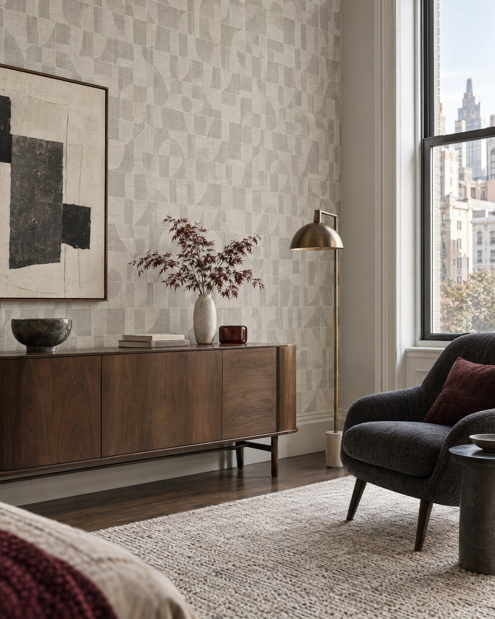 Textured geometric wallcovering behind a walnut console and charcoal lounge chair