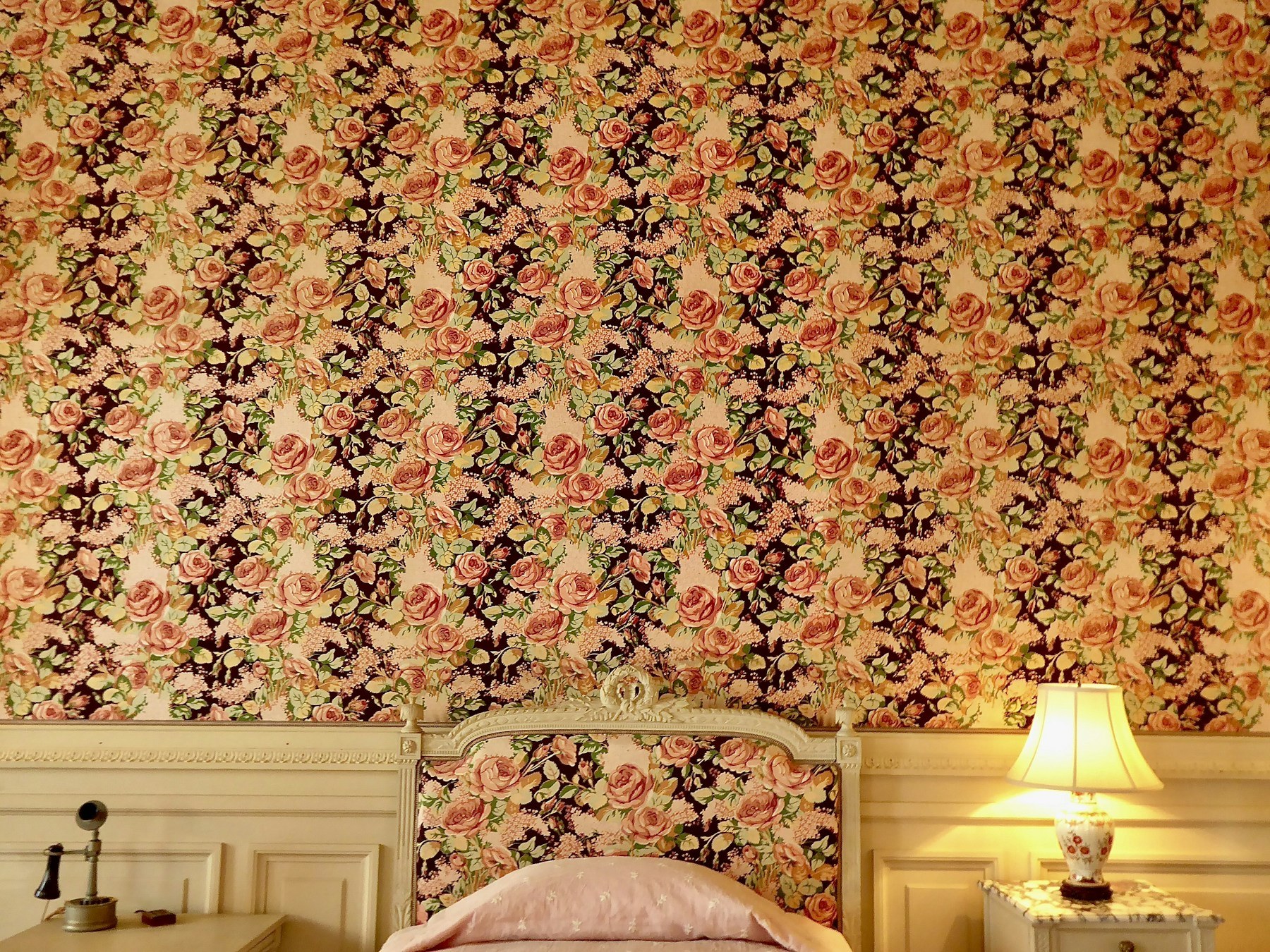 Close view of a repeating floral wallpaper pattern in warm neutral tones